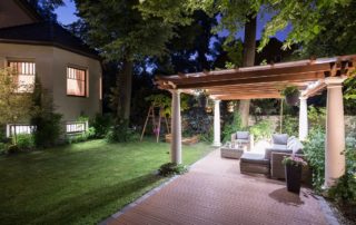 A garden with covered patio at night